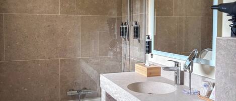 A modern bathroom with a bathtub, a sink with a mirror, and a shower area.
