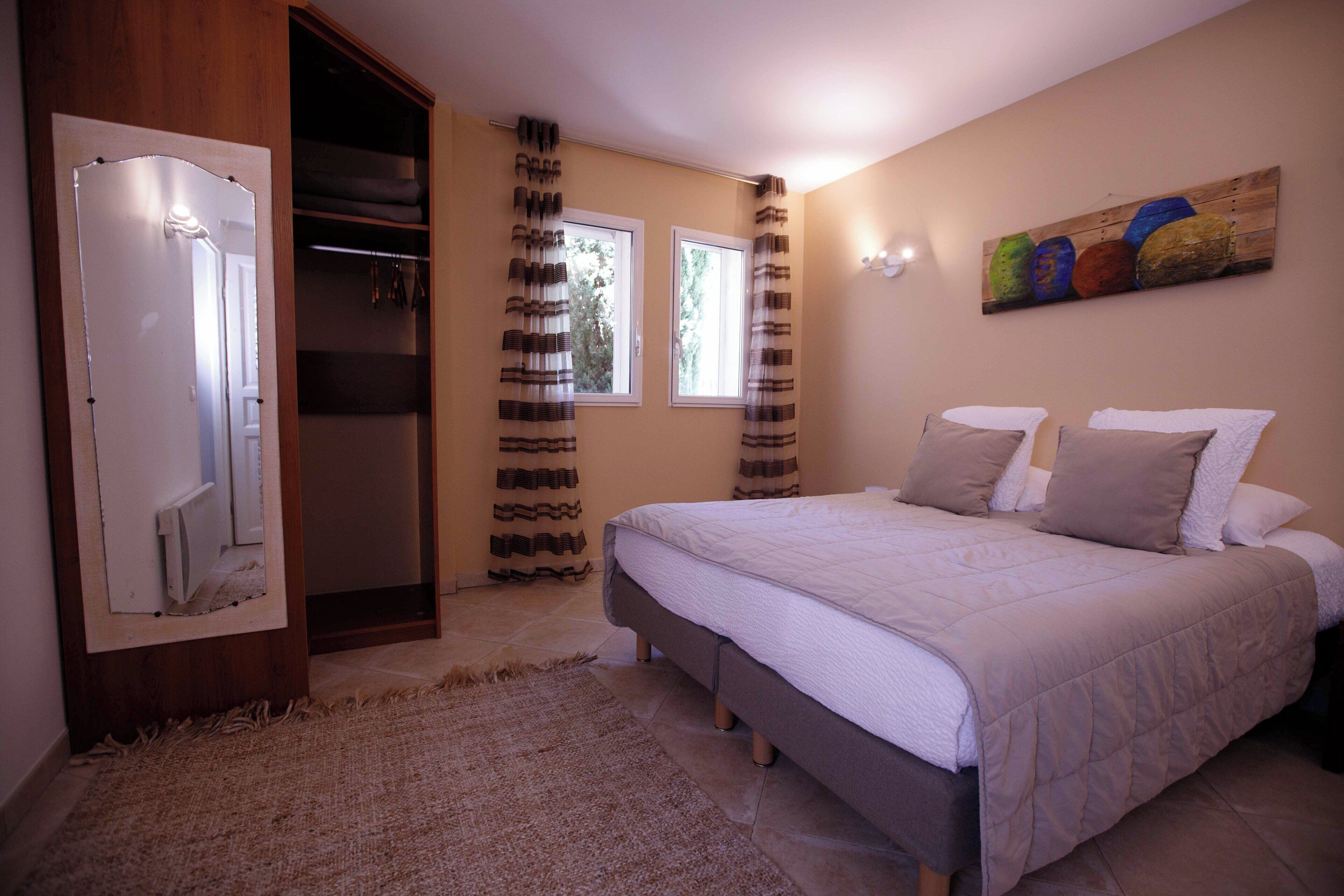 A bedroom with a bed, a wardrobe, and a painting on the wall.