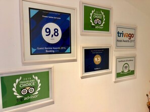 Framed awards for a hotel, including a 9.8 rating from Guest Review Awards 2016 and a 9.3 rating from TripAdvisor. - Flower Suites Sorrento (Sorrento)