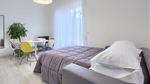 Un dormitorio moderno con una cama grande, un escritorio y una silla.
