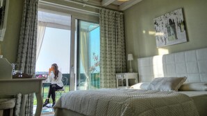 Una camera da letto con un letto, un comodino, una lampada e una finestra con tende.