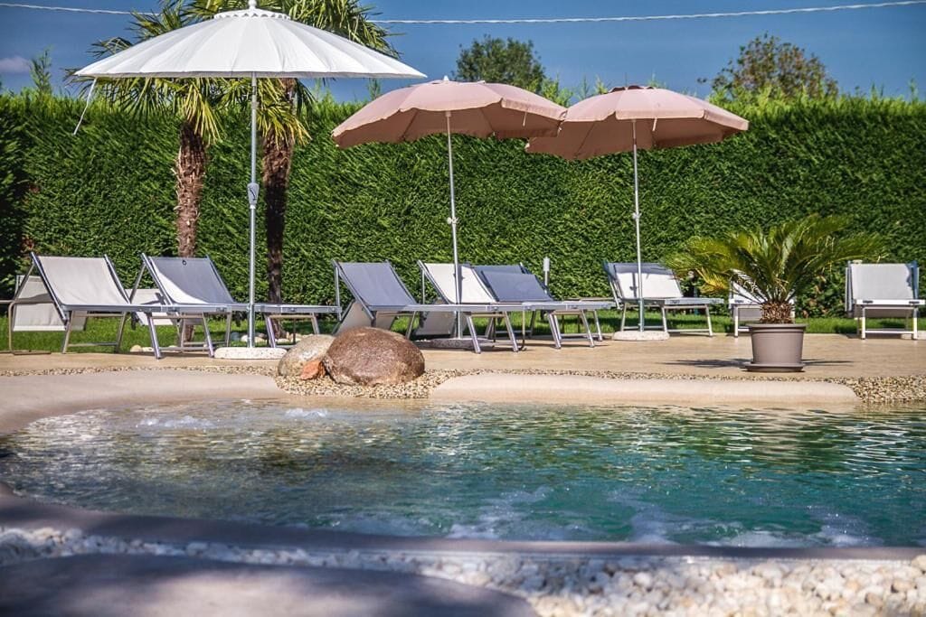 Una piscina al aire libre de temporada, sombrillas