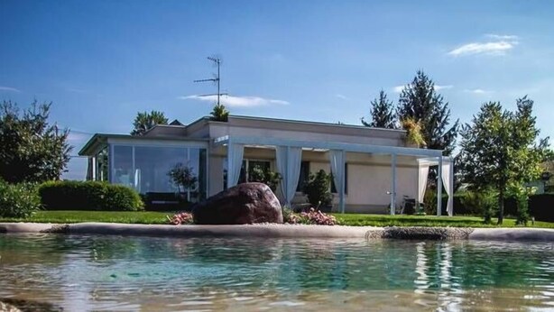 Una casa con una piscina di fronte.