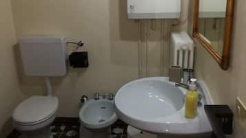 Un baño pequeño con inodoro, lavabo y espejo.