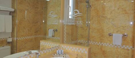 A bathroom with a large mirror, a sink, a shower, and a bathtub.