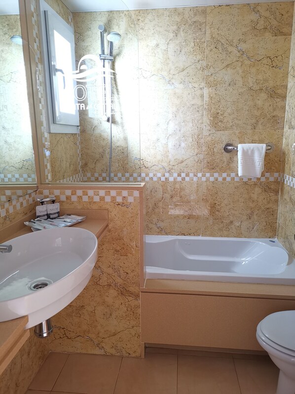 A bathroom with a sink, bathtub, and toilet. - Hotel Punta del Cantal (Mojacar)
