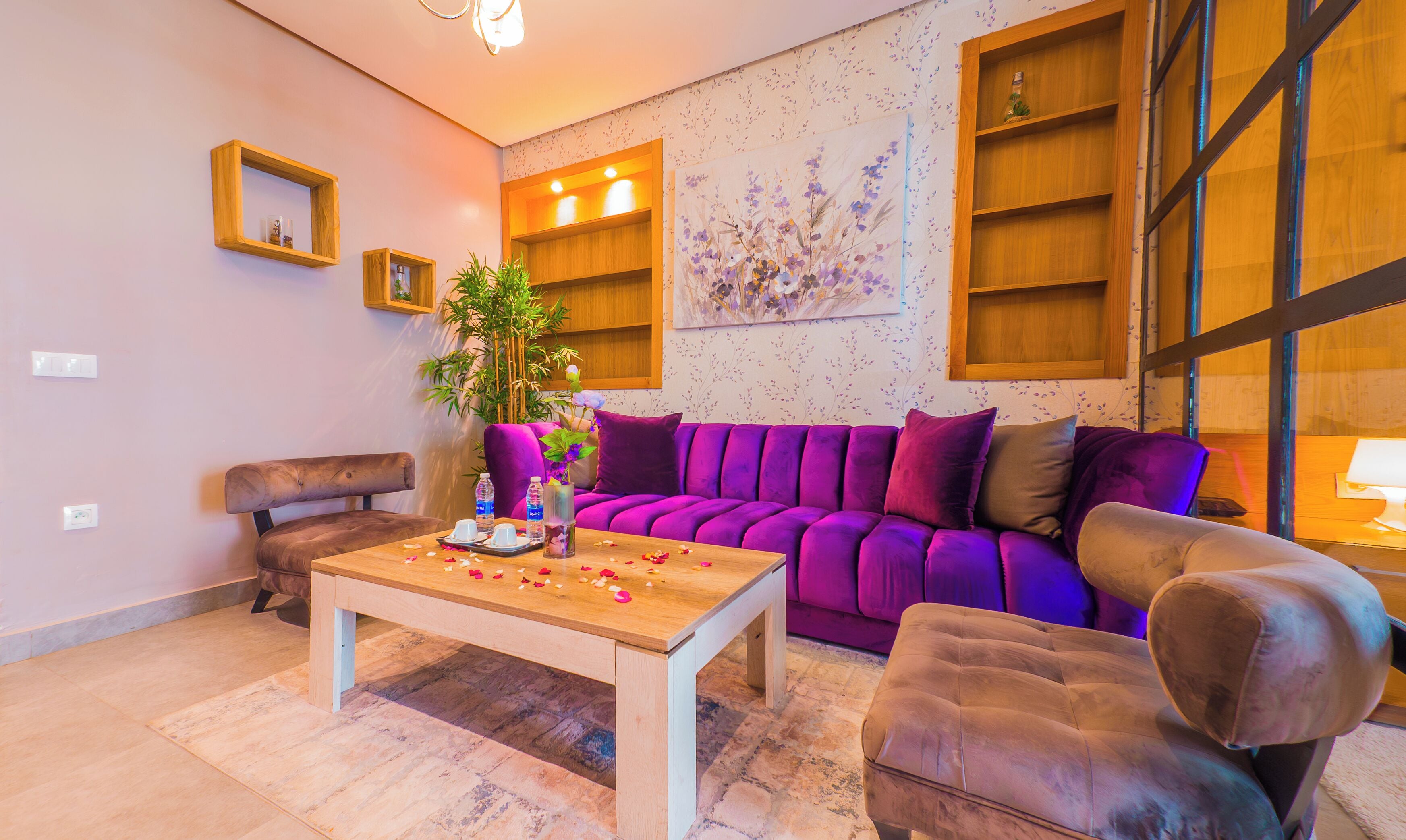 A modern living room with a purple sofa, a wooden coffee table, and a brown armchair.