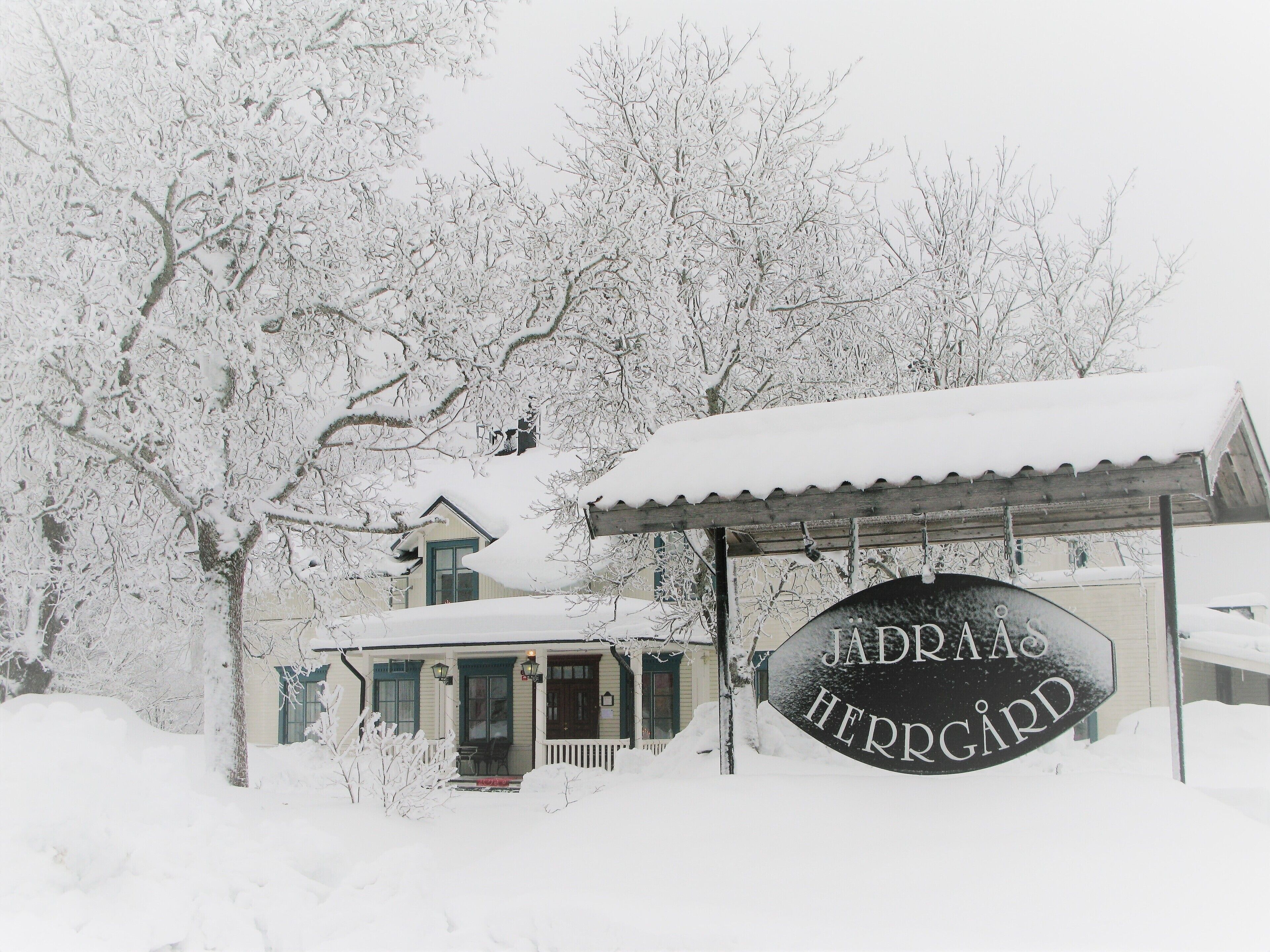 Un edificio cubierto de nieve con un letrero que dice "JADRAHS HERREGARD".