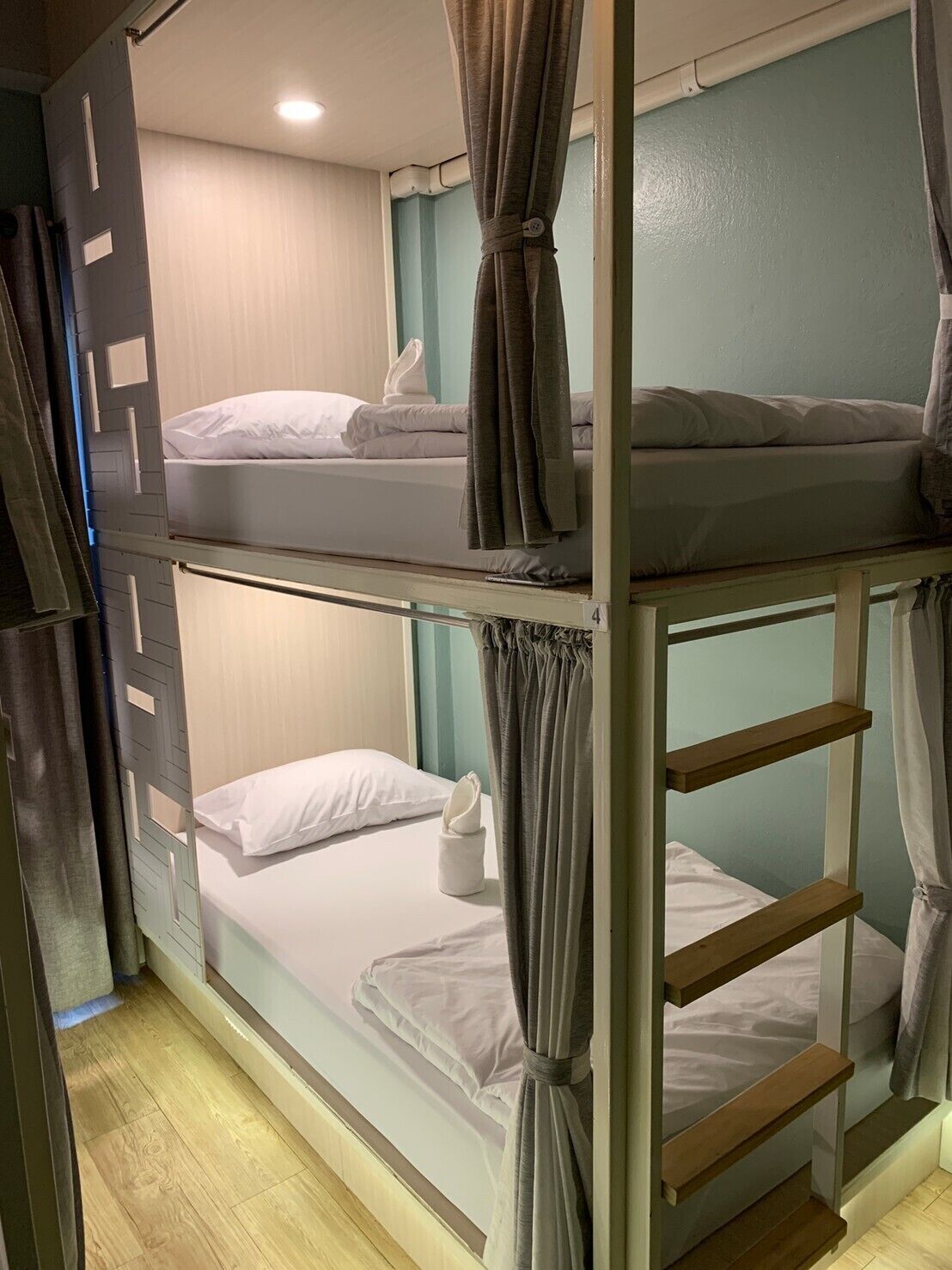 Een slaapkamer met een stapelbed, twee bedden, elk met een kussen en een handdoek.