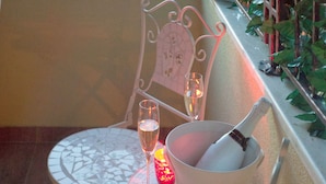 A balcony with a table, a chair, a glass of champagne, and a bottle of Krug champagne.