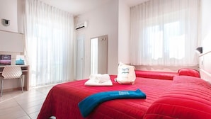A hotel room with two beds, a desk, and a chair. - Hotel Foglieri (Cesenatico)