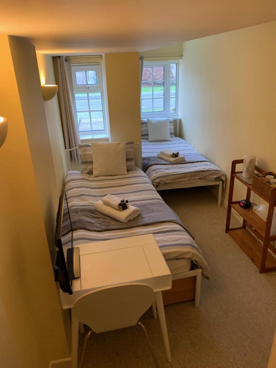 Une chambre d’hôtel avec deux lits, un bureau et une chaise.