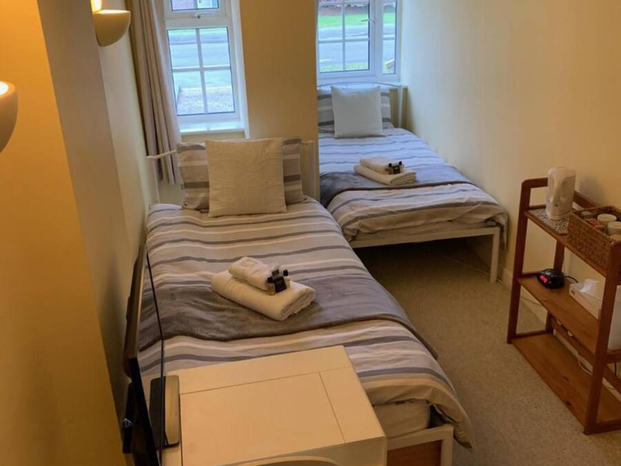 Une chambre d’hôtel avec deux lits, un bureau et une chaise.