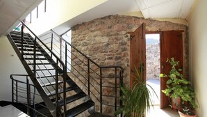 A staircase with a metal railing leading to a stone wall. There are potted plants near the wall. - Hotel Casa Palacio (Montanejos)