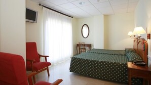 A hotel room with a bed, a desk, a chair, a TV, and a lamp. - Hotel Casa Palacio (Montanejos)