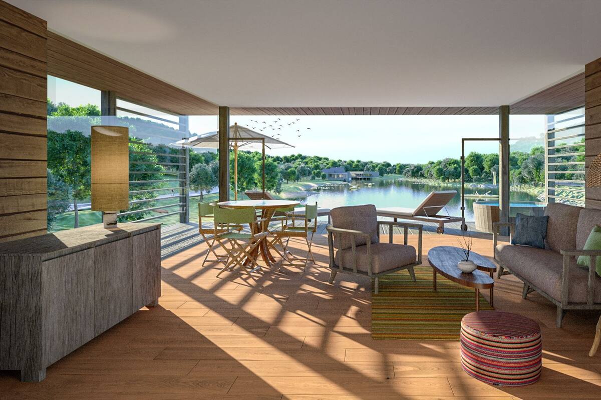 A modern interior with a wooden floor, a dining area with chairs and a table, a sofa, a lamp, and a view of a lake and greenery outside.