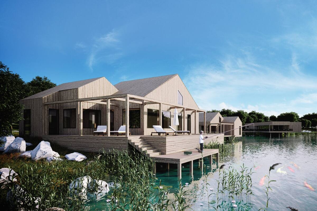 A wooden houseboat with a deck and lounge chairs, surrounded by water and greenery.