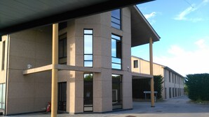Un edificio moderno con techo plano, ventanas amplias y fachada de hormigón.