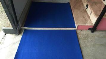 Una rampa con moqueta azul que da acceso a una habitación.