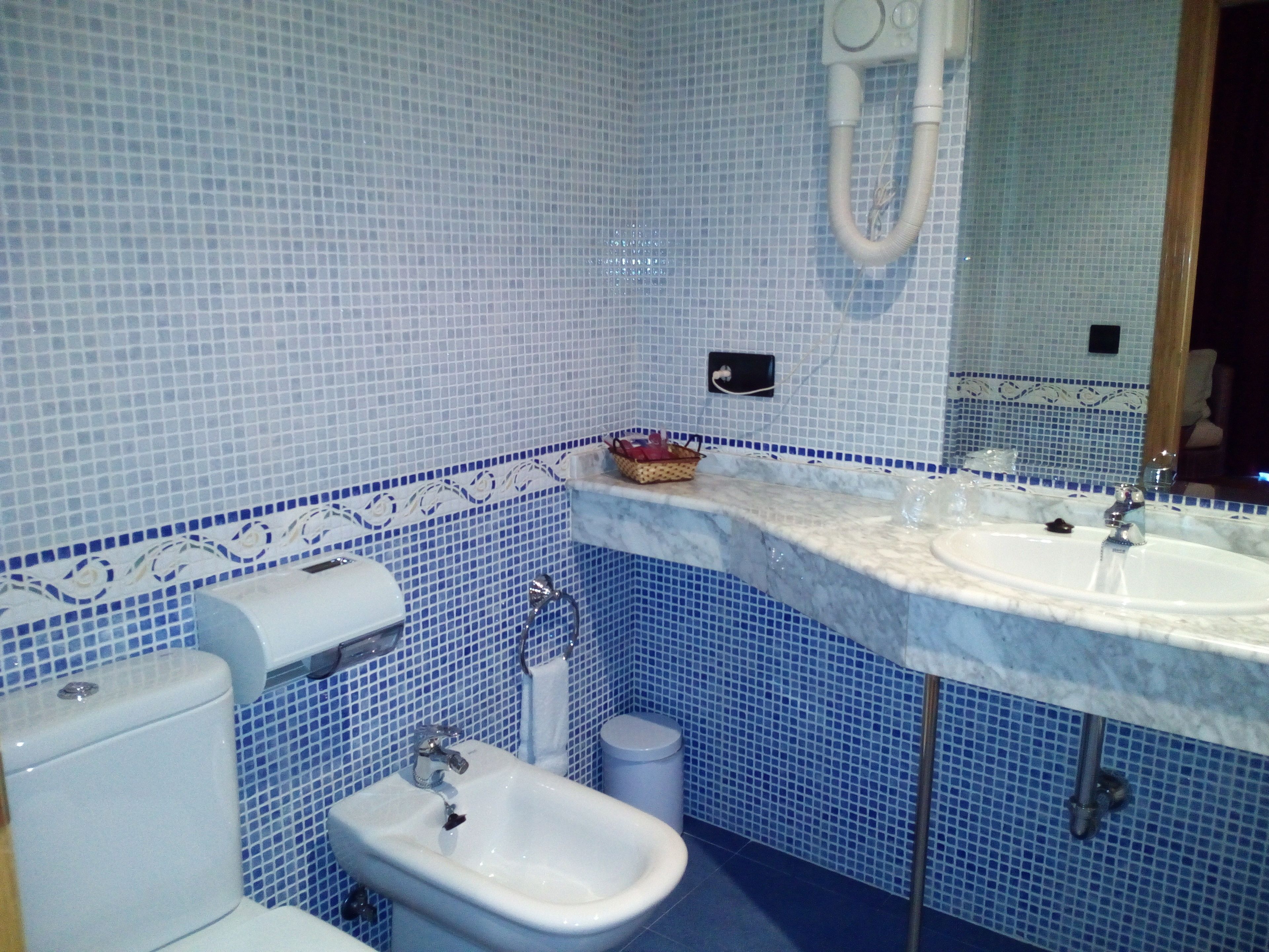 Un baño con inodoro, lavamanos y bidé.