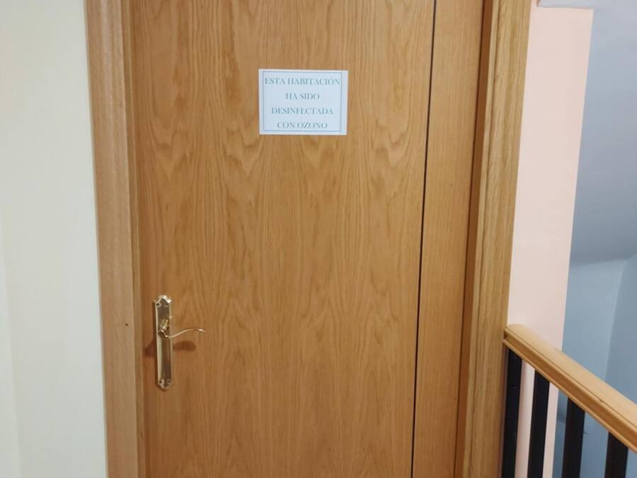 A wooden door with a sign stating the room has been disinfected with ozone.