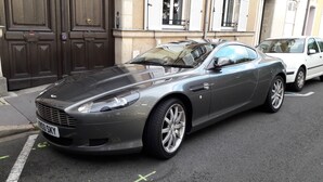 A dark-colored sports car parked on a street. - Les Lamartine (Le Mans)