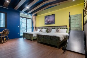 Quarto com duas camas de madeira, uma mesa de jantar com cadeiras e uma janela grande com cortinas.