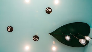 Een plafond met ronde lampen en een grote lamp in de vorm van een blad.