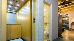 Een lift met een digitaal scherm, een houten afwerking en een vloerbedekking.