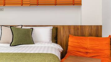 A hotel room with a bed, a wooden headboard, and a window with blinds.