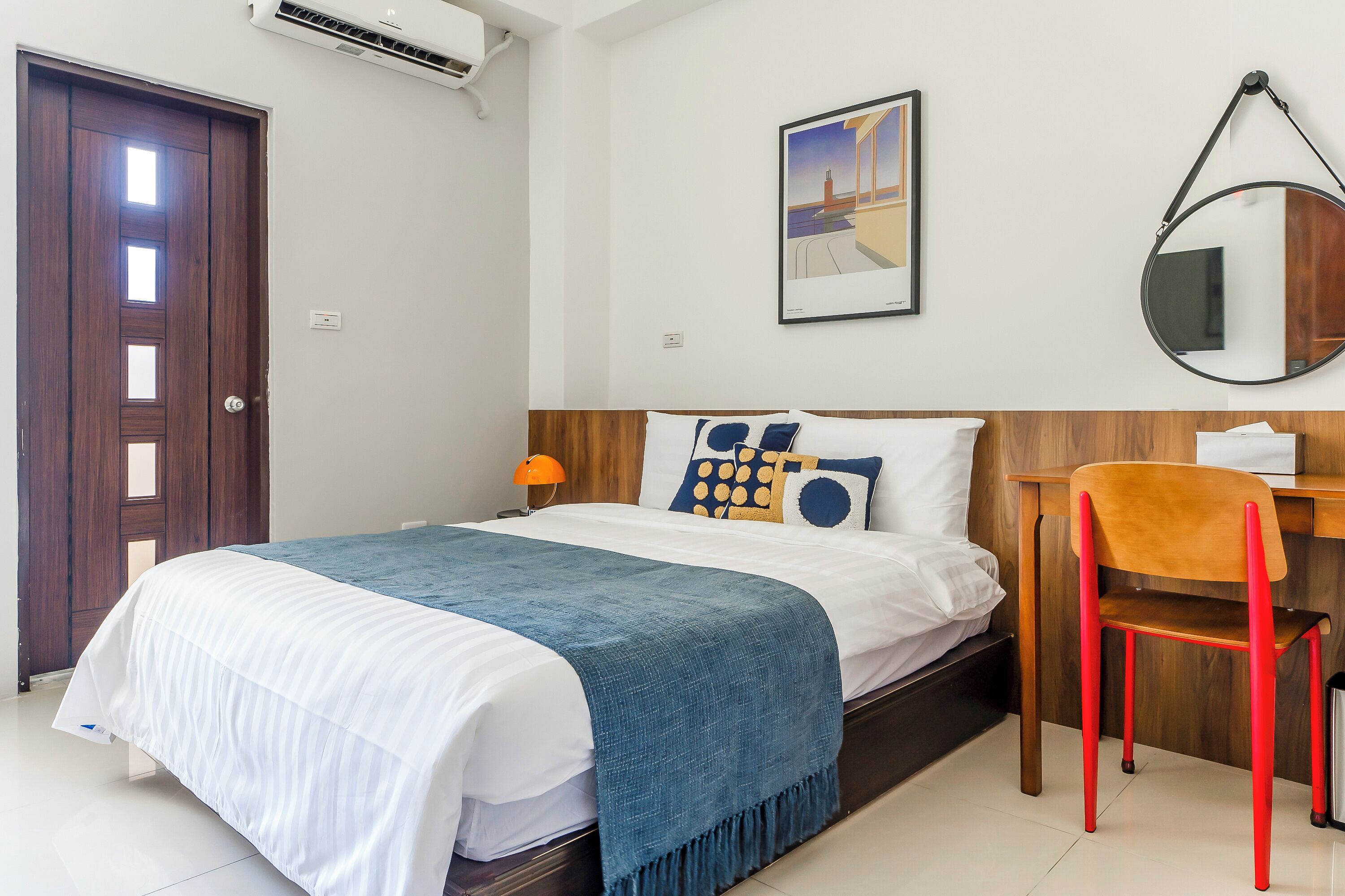 A neatly arranged bedroom with a bed, a desk, and a chair.