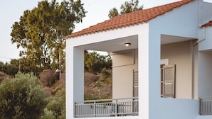 A modern two-story building with a swimming pool, outdoor seating, and a garden area. - Iphigenia Mythic Retreat (Hersonissos)