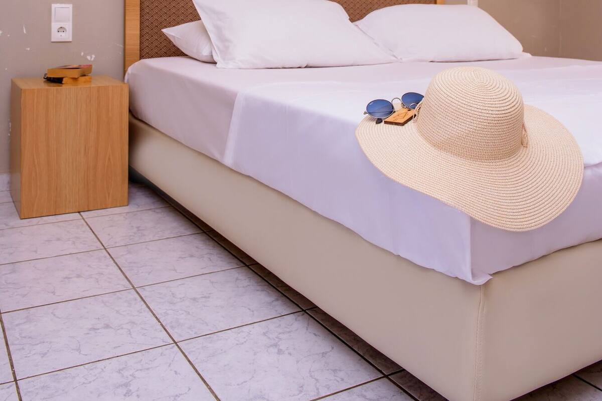 Ein Schlafzimmer mit einem Bett, einem Nachttisch und zwei Wandleuchten.