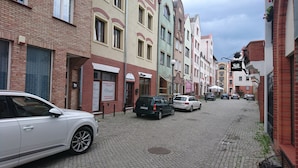 Een straat met keien, geflankeerd door meerverdiepinggebouwen, waarvan enkele winkelpanden herbergen.