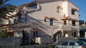 A two-story building with a flat roof and a balcony on the second floor. - Piano (Lopar)