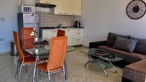 A compact living space with a kitchenette, dining area, and seating area. - Piano (Lopar)