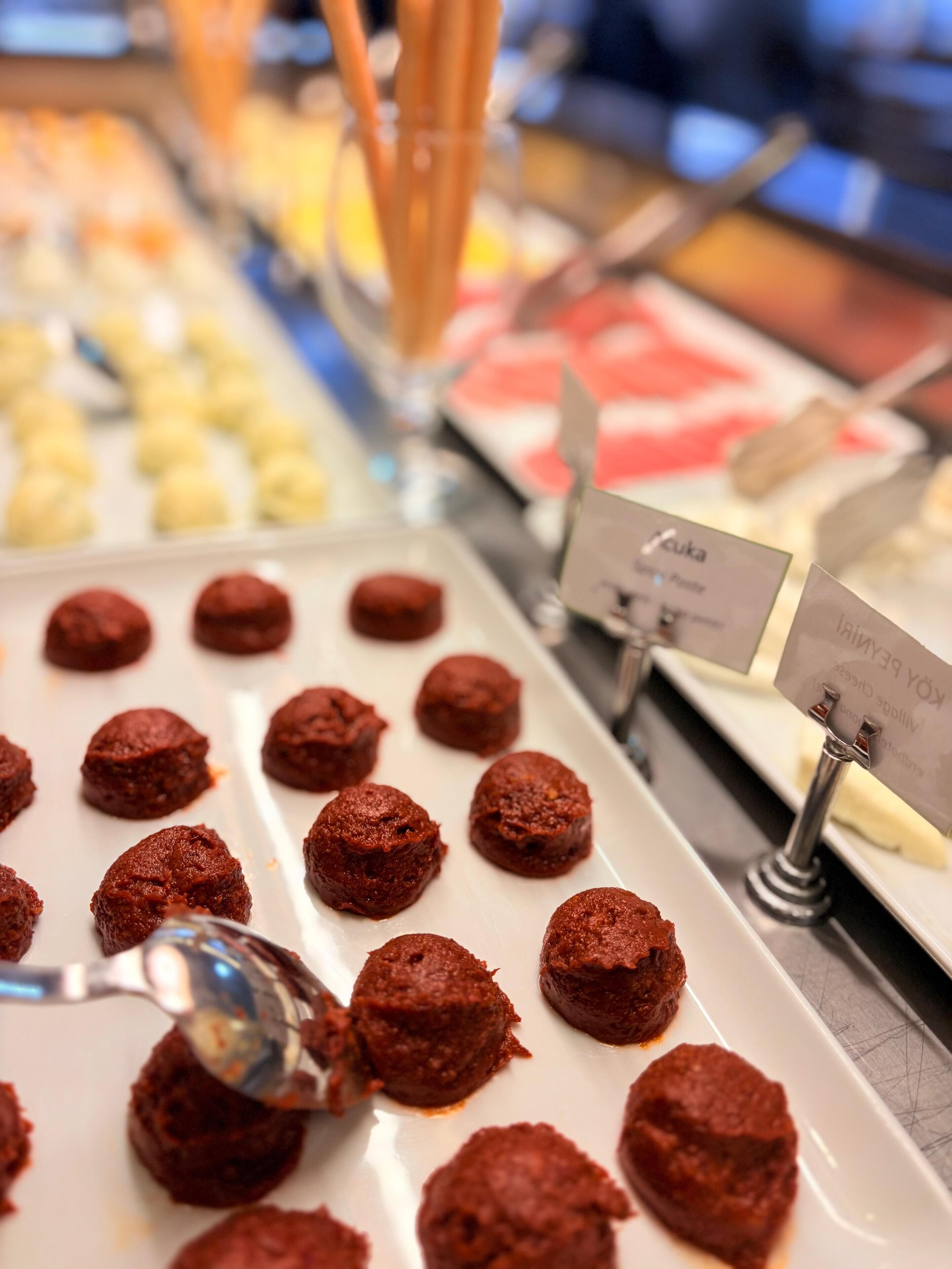 Un présentoir de desserts proposant une variété de douceurs, notamment des truffes au chocolat et d’autres confiseries.