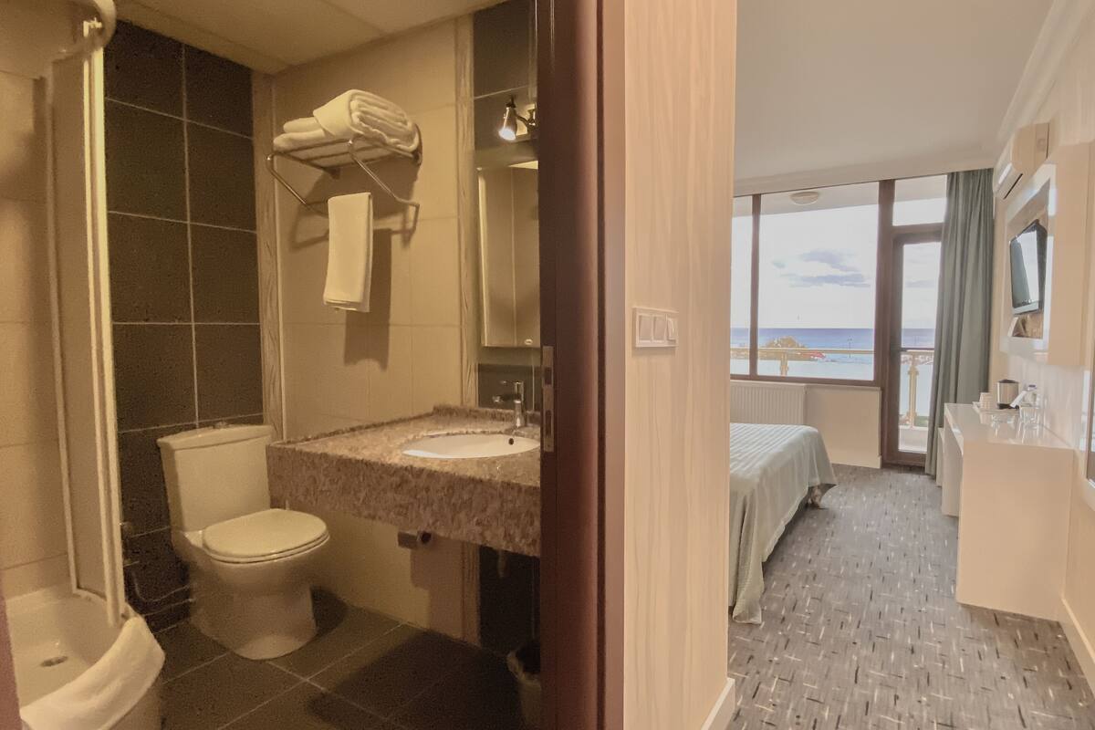 A bathroom with a toilet, sink, and towel rack.