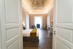 Een hotelkamer met een groot bed, een bureau, een stoel en uitzicht op de omgeving.