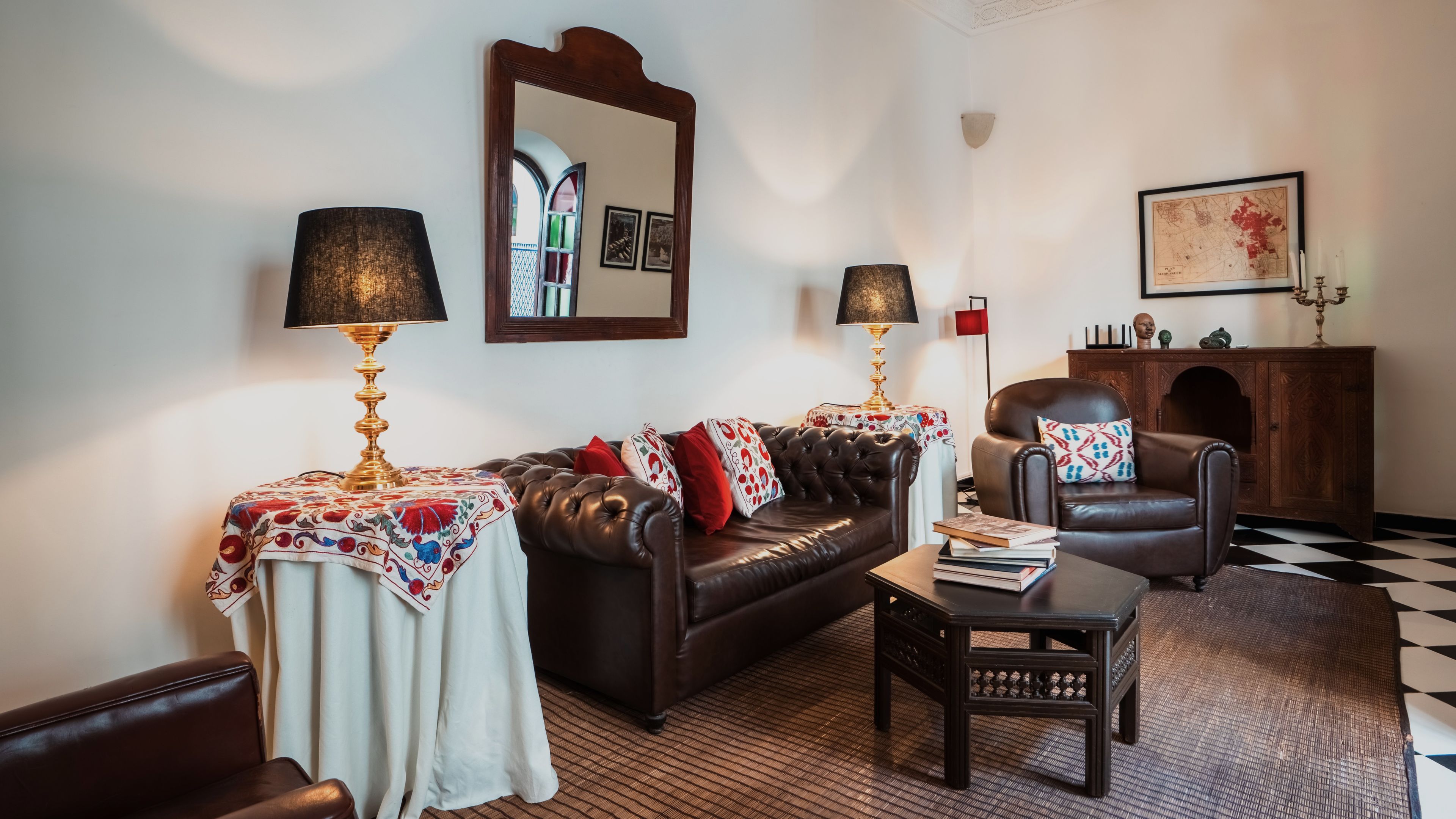 A living room with a leather sofa, two side tables with lamps, a coffee table, and a patterned rug.