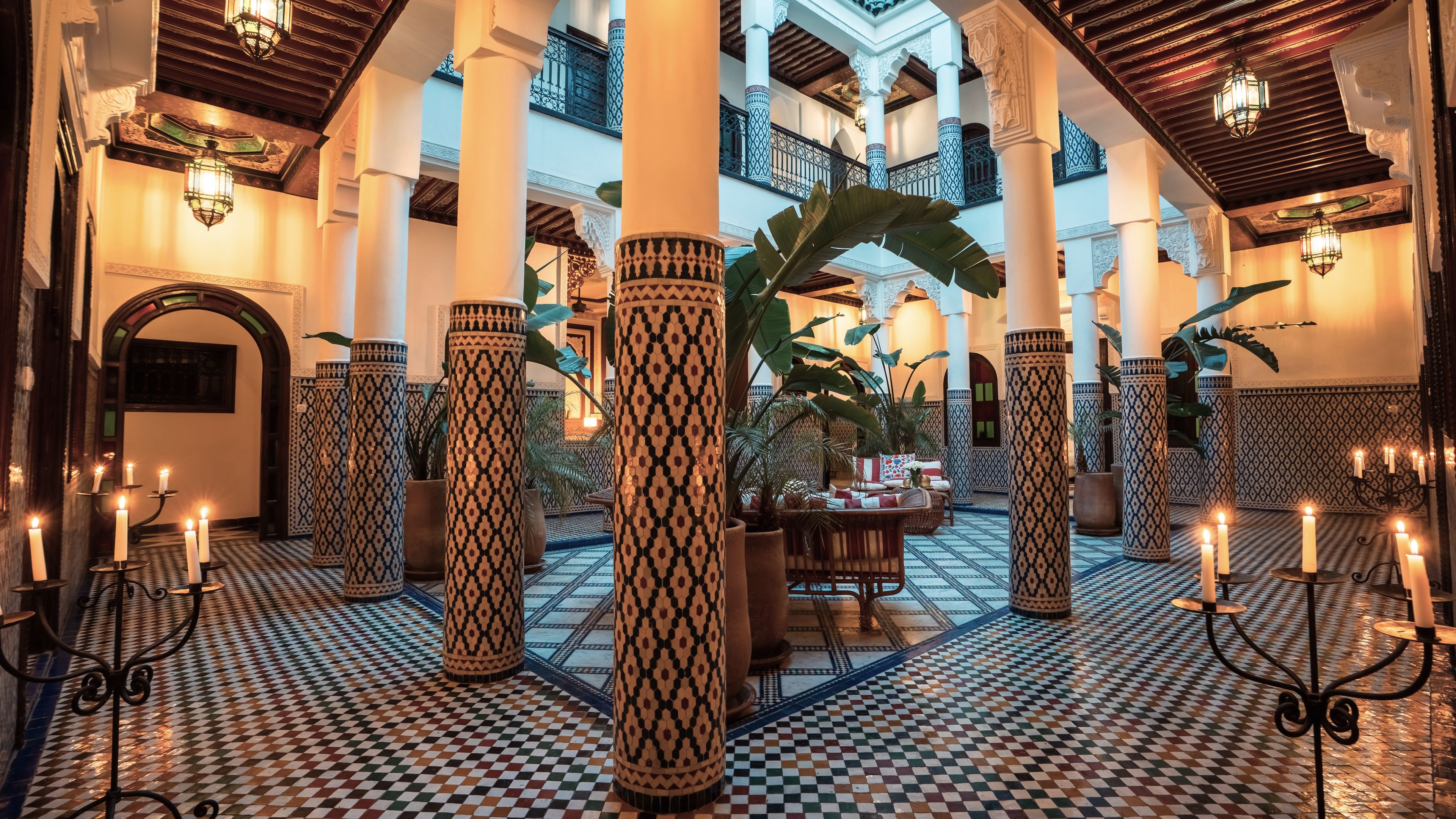 A spacious lobby with high ceilings, ornate columns, and a checkered floor pattern.