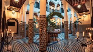 A spacious lobby with high ceilings, ornate columns, and a checkered floor pattern. - Riad Yakimour (Marrakech)