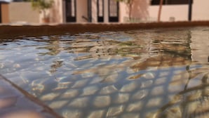 Una piscina con agua cristalina que refleja el entorno.