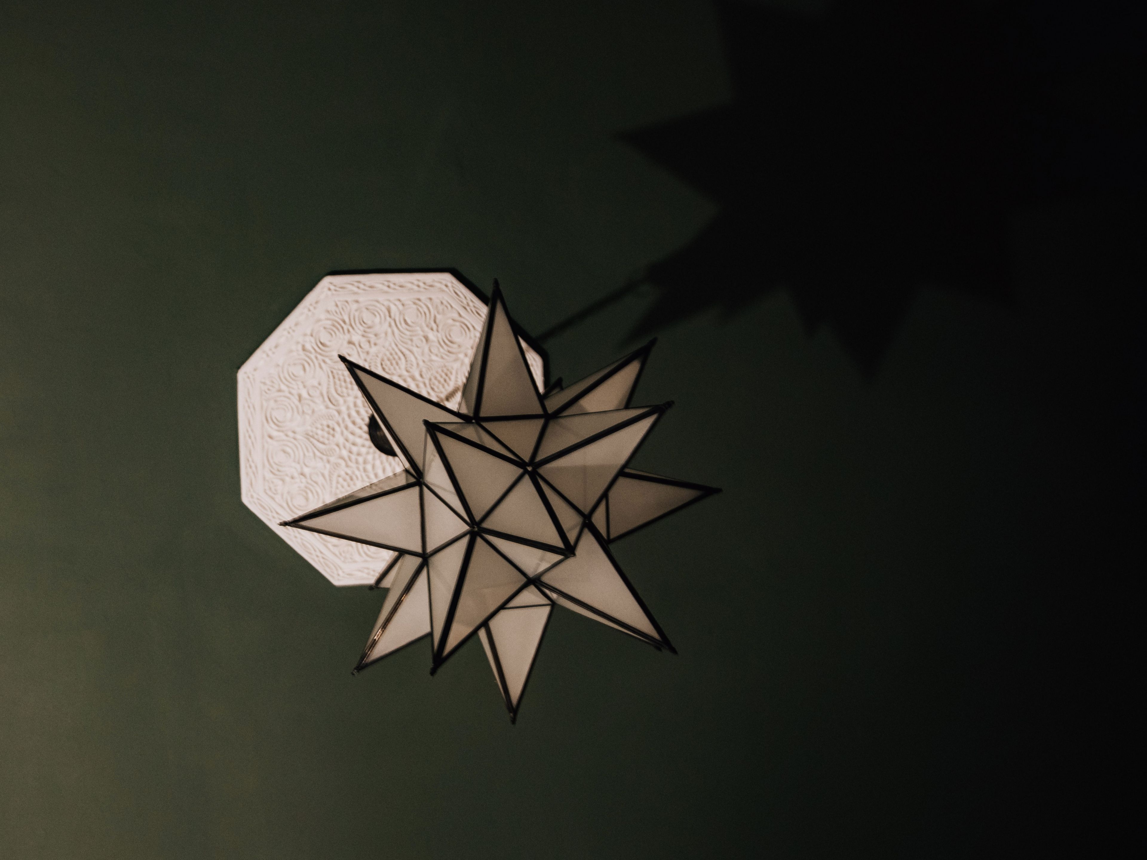Eine geometrische Leuchte mit sternförmigem Design vor dunklem Hintergrund.