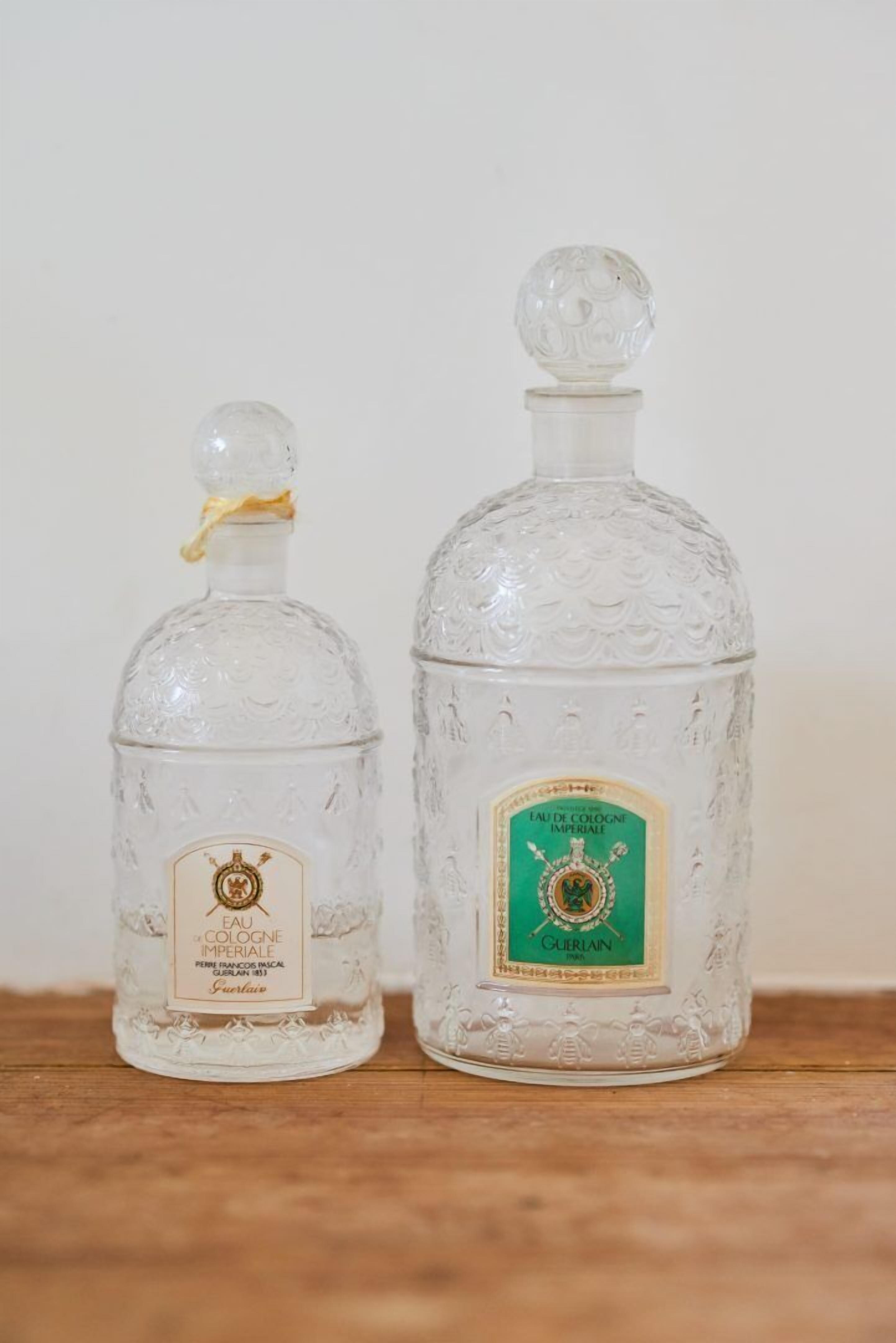 Two glass decanters with labels, placed on a wooden surface against a plain background.