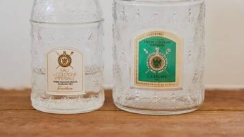 Two glass decanters with labels, placed on a wooden surface against a plain background.