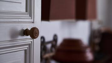 A white door with a wooden knob and a brass handle.