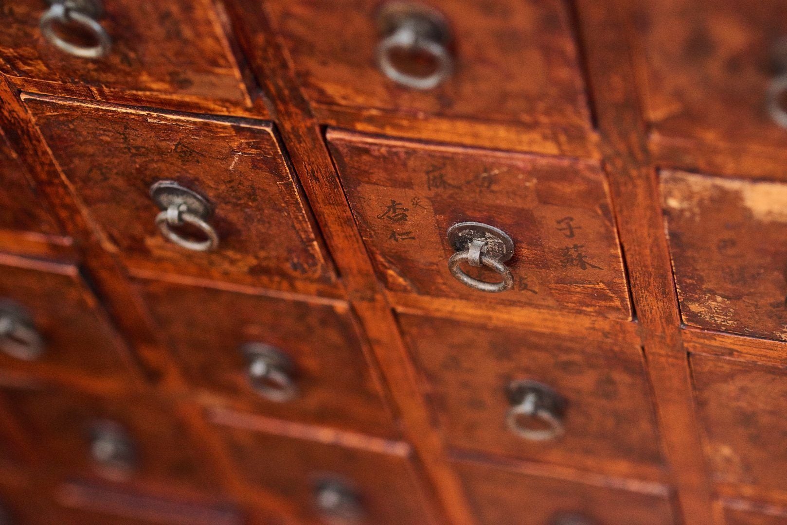 Primer plano de cajas de madera con anillos metálicos, probablemente usadas para organizar objetos.
