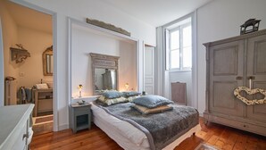 Un dormitorio con una cama grande, un aparador, un tocador y un armario.