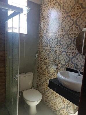 A bathroom with a toilet, shower, and sink. - Casa Acolhedora no Paraíso (Arraial do Cabo)